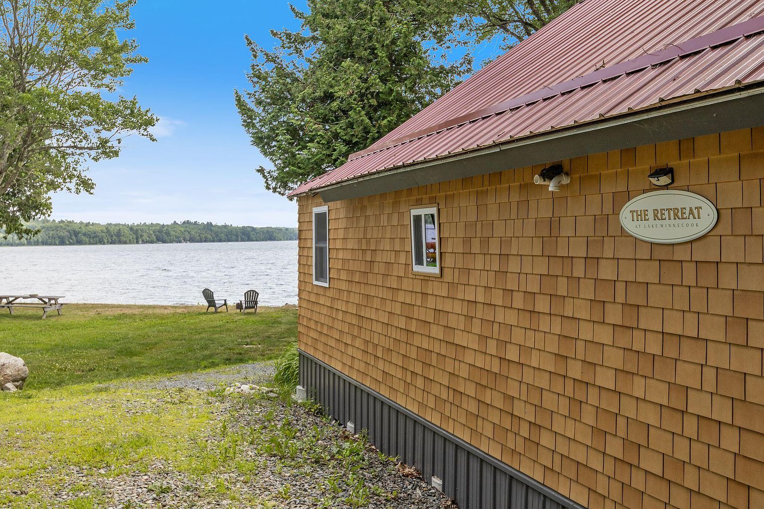 A second cabin interior with a leather sofa, white refrigerator, gas range, and timber post detail.